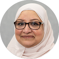 A photo of a woman smiling and wearing glasses and a white hijab