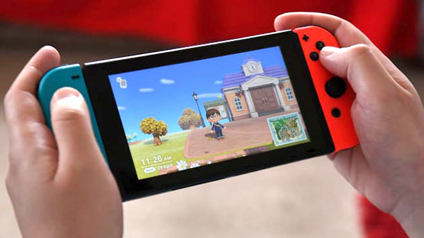 Two hands holding a Nintendo Switch with a scene from Animal Crossing: New Horizons on the screen.