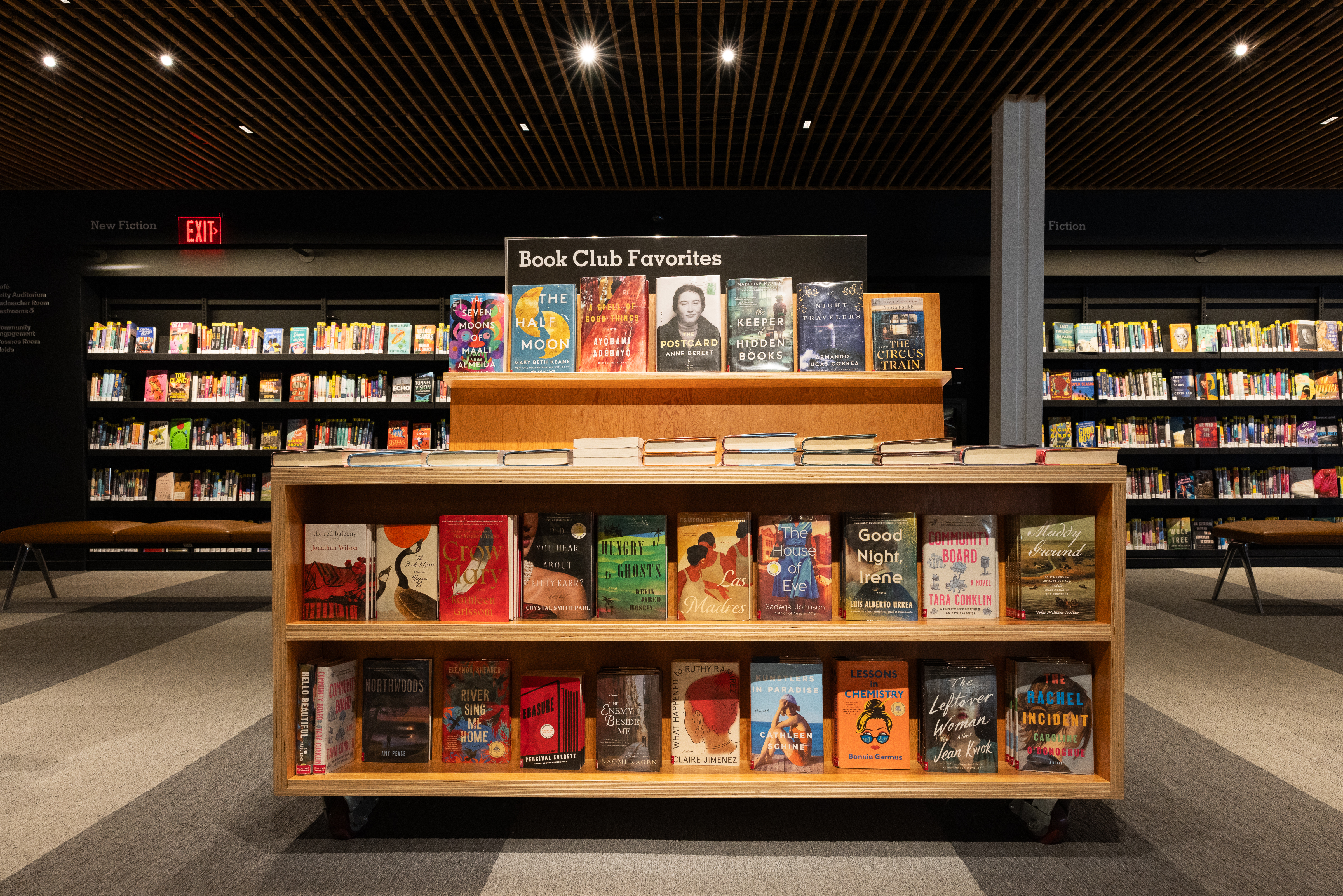 view of free-standing book display shelf. Sign reads "Book Club Favorites"