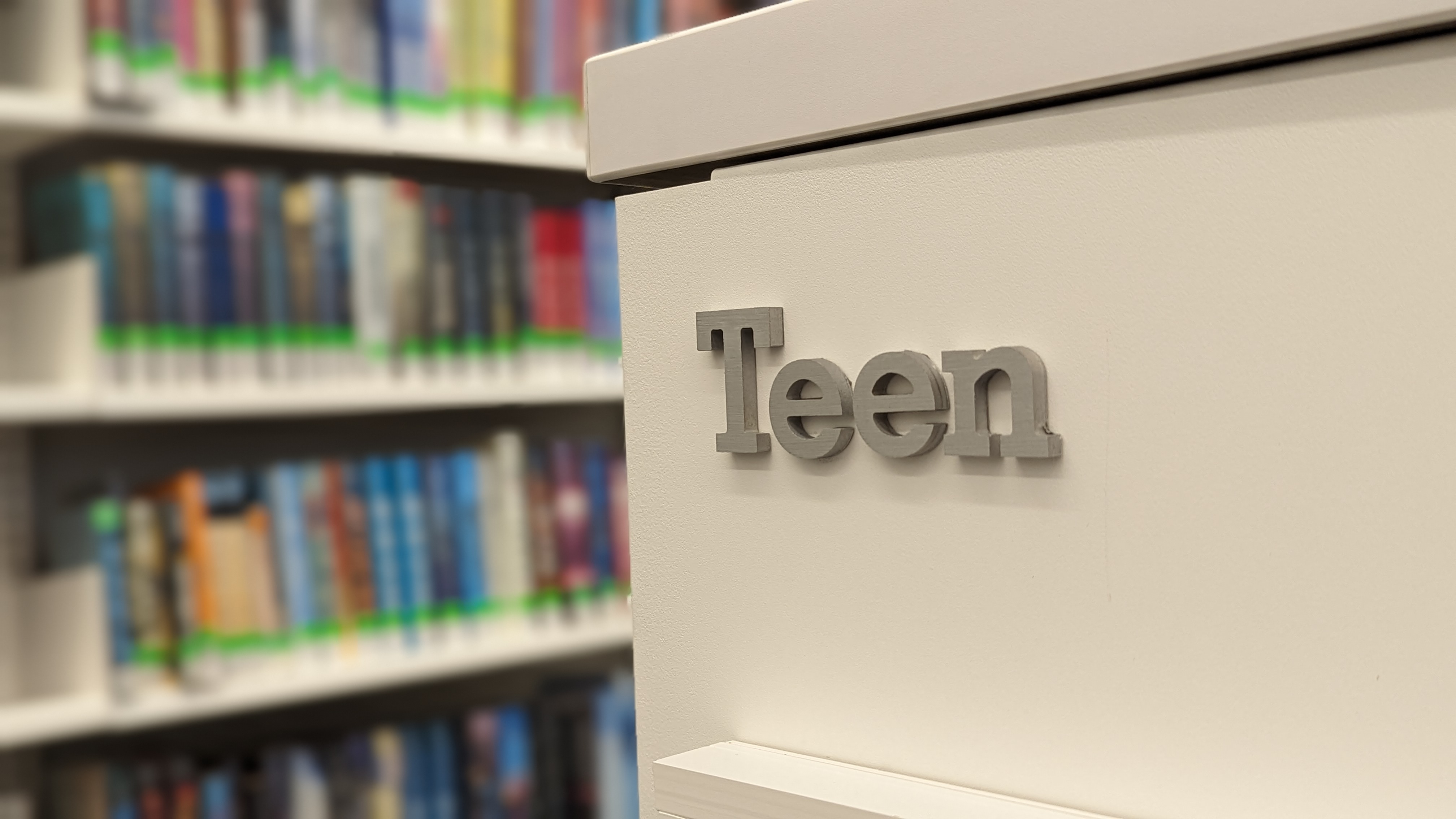 close-up of book shelf, it reads, "Teen."