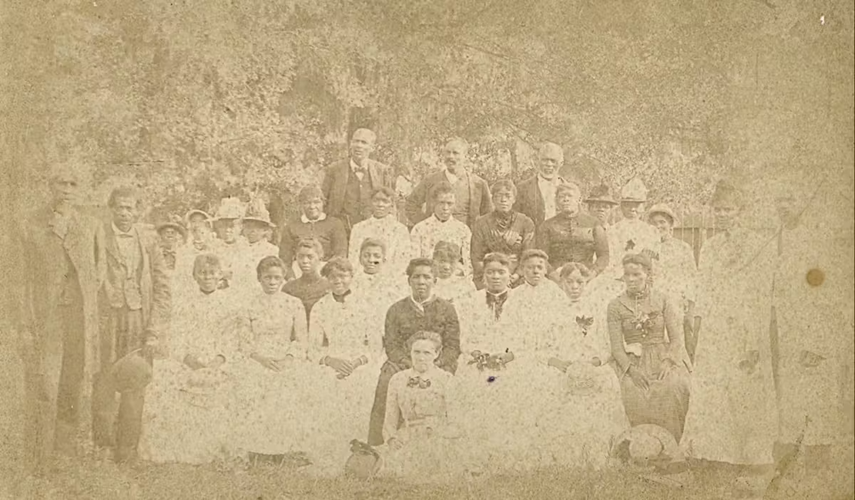 old photograph of a group of Black people standing and sitting in a park, posing for a picture . old photograph of a group of Black people standing and sitting in a park, posing for a picture .